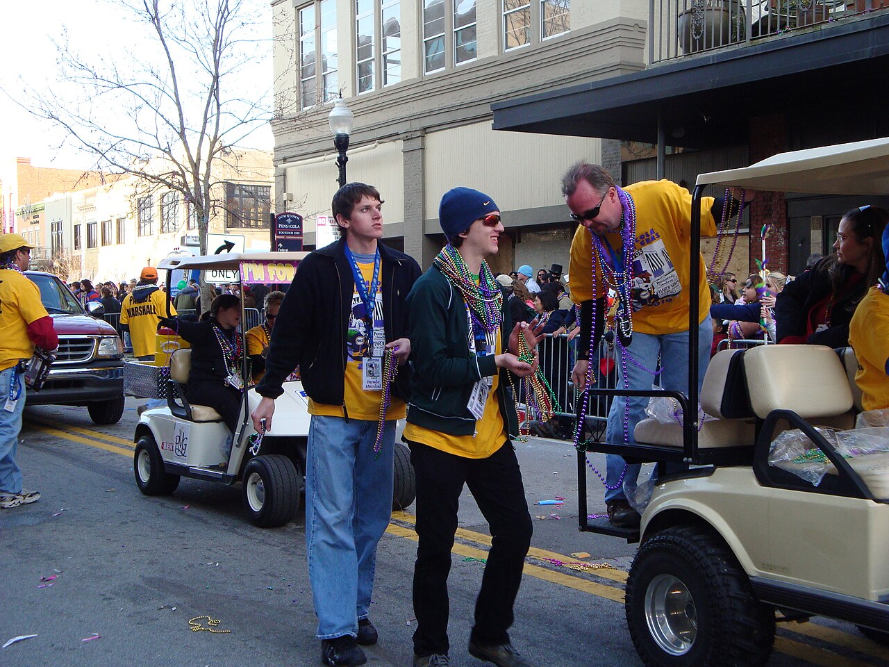 Mardi Gras throws changing hands in a crowd on a downtown Pensacola parade route